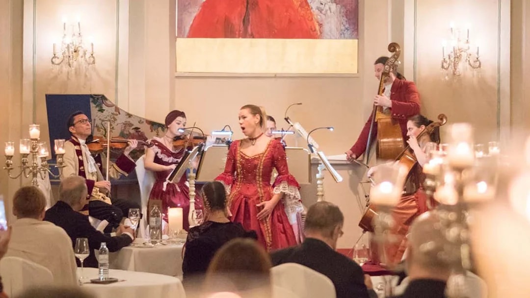 Musicians in period costumes perform at a Mozart concert in a historic Salzburg venue.