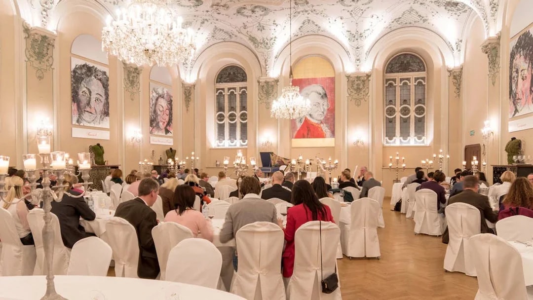 Musicians in period costumes performing at a Mozart concert in a historic Salzburg venue.
