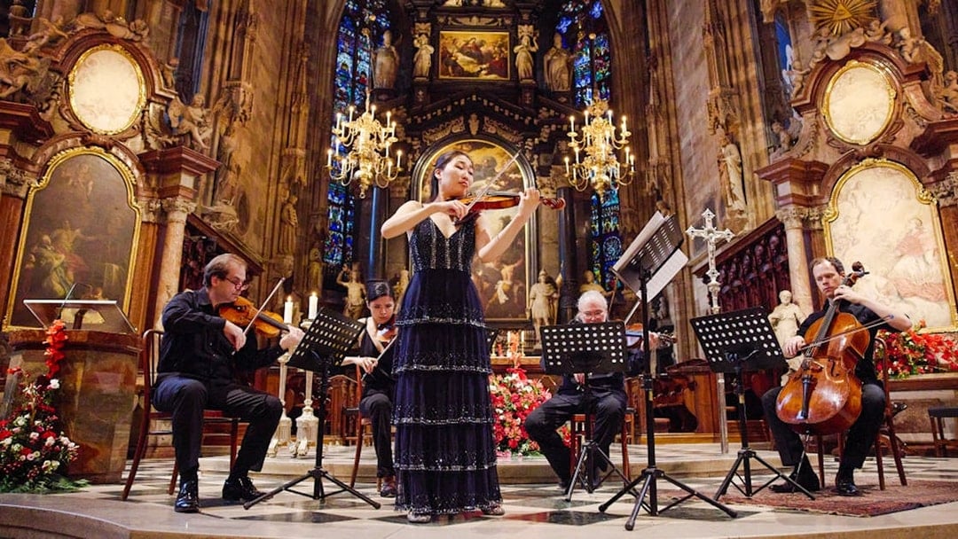 Performers playing string instruments inside St. Stephen's Cathedral, Vienna.