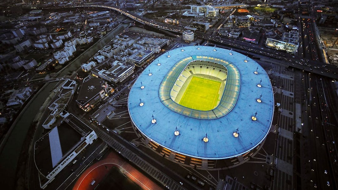Aerial view of Stade de France in Saint-Denis, Paris, illuminated at night.