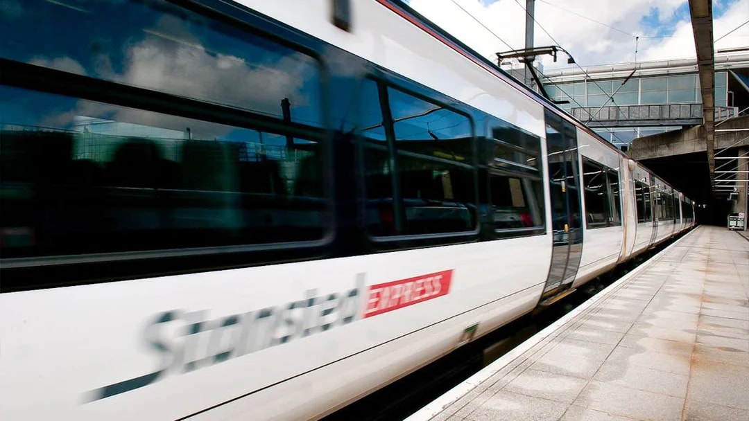 Stansted Express train arriving at a modern train station platform.