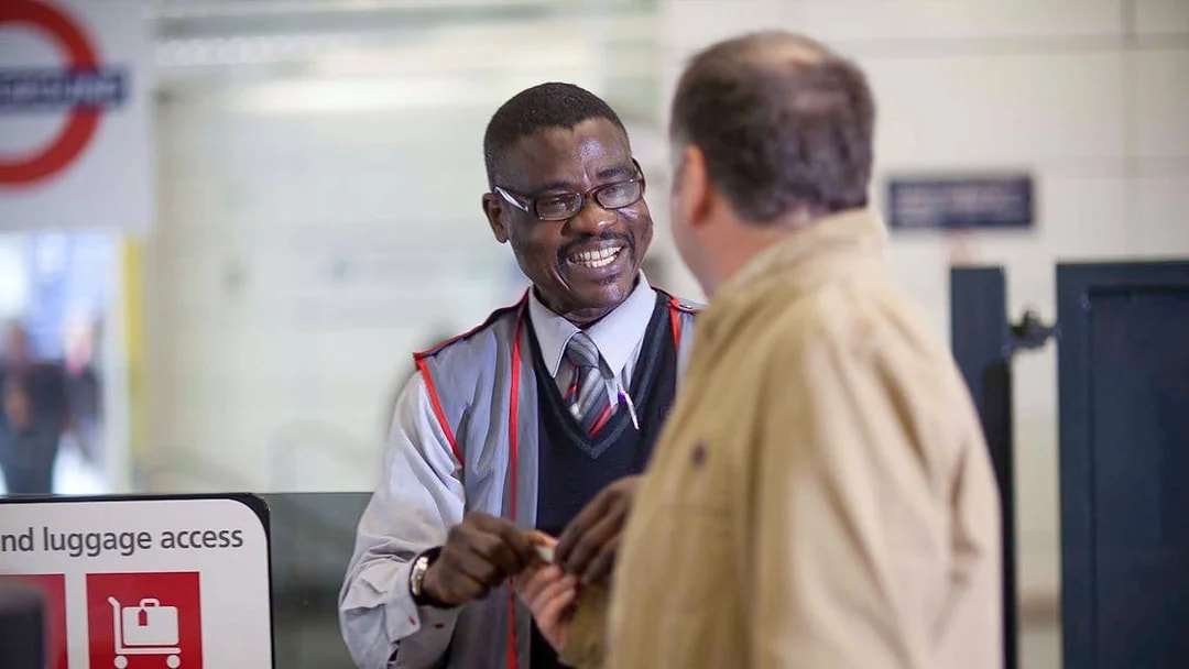 Customer interacting with staff while boarding Stansted Express.
