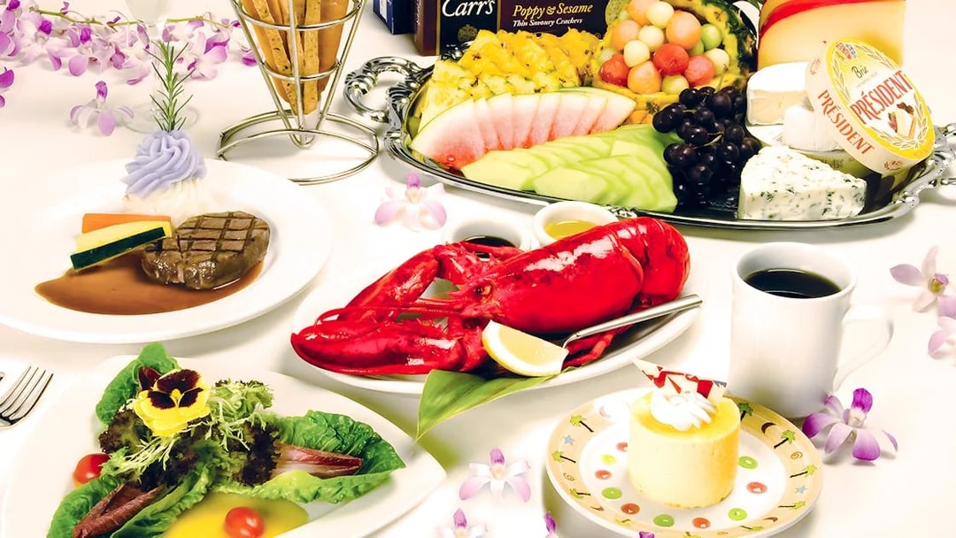 Dinner spread featuring lobster, steak, salad, and dessert on the Star of Honolulu, Three Star.