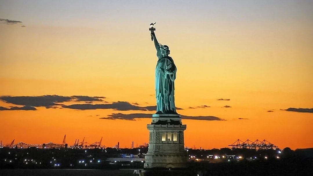Statue of Liberty at sunset during Ellis Island sightseeing cruise.