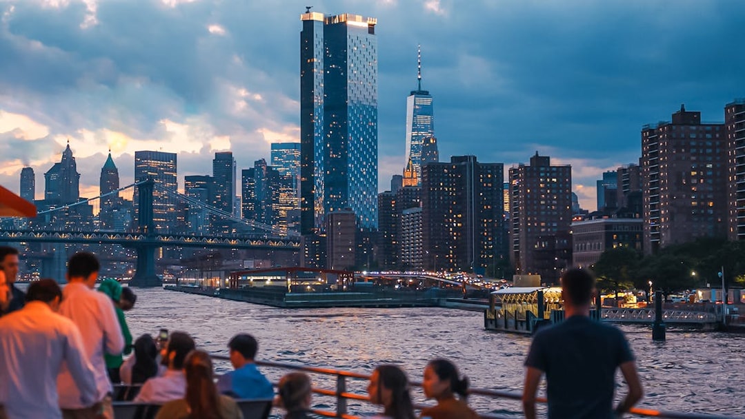 New York City skyline at night with people on a boat tour.