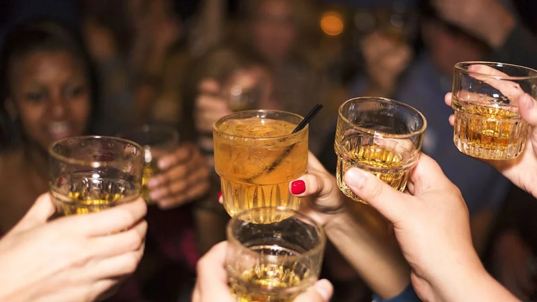 Guests toasting drinks during Statue of Liberty Ellis Island Sunset Cruise bar experience.