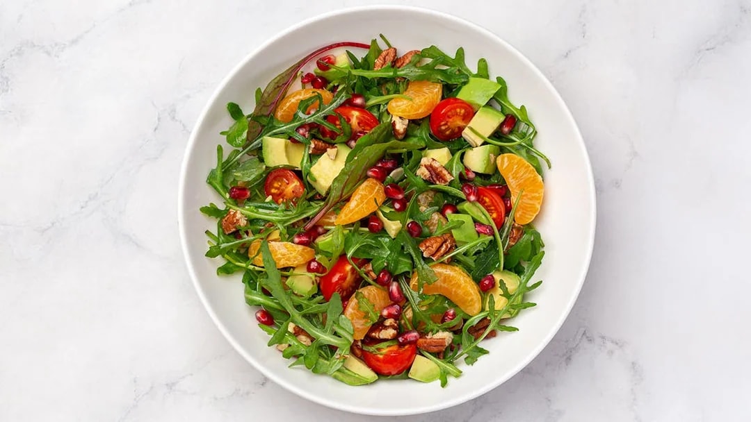 Tossed salad with arugula, cherry tomatoes, avocado, pecans, and citrus served on Steamboat Natchez Dinner Cruise.