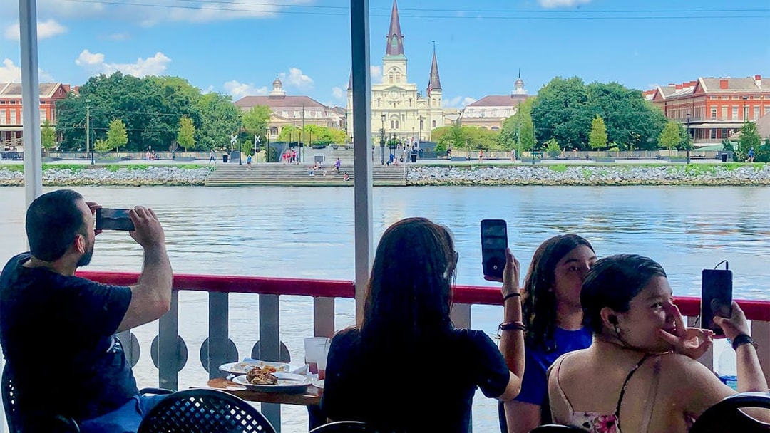 People photographing the view of St. Louis Cathedral from Steamboat Natchez in New Orleans.