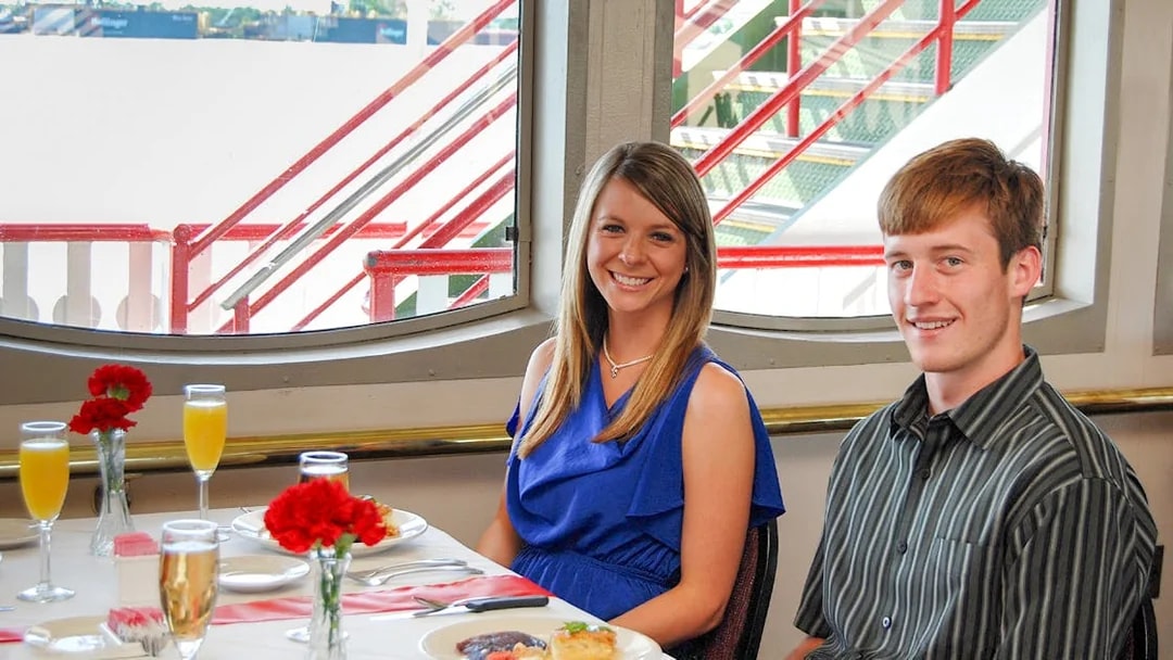 Guests enjoying brunch on the Steamboat Natchez with river view.