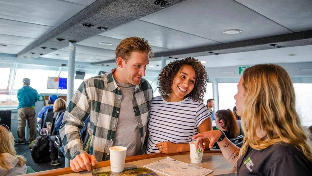 Couple talking to staff at the cafeteria on board the Stewart Island Ferry.