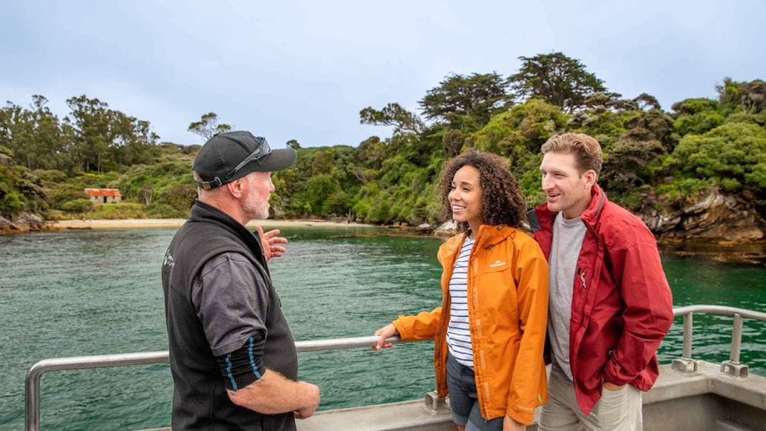 Tour guide explaining Ulva Island's features to visitors on a boat.
