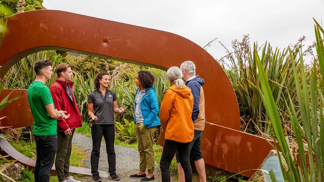 Tour group with guide at Stewart Island sculpture garden.