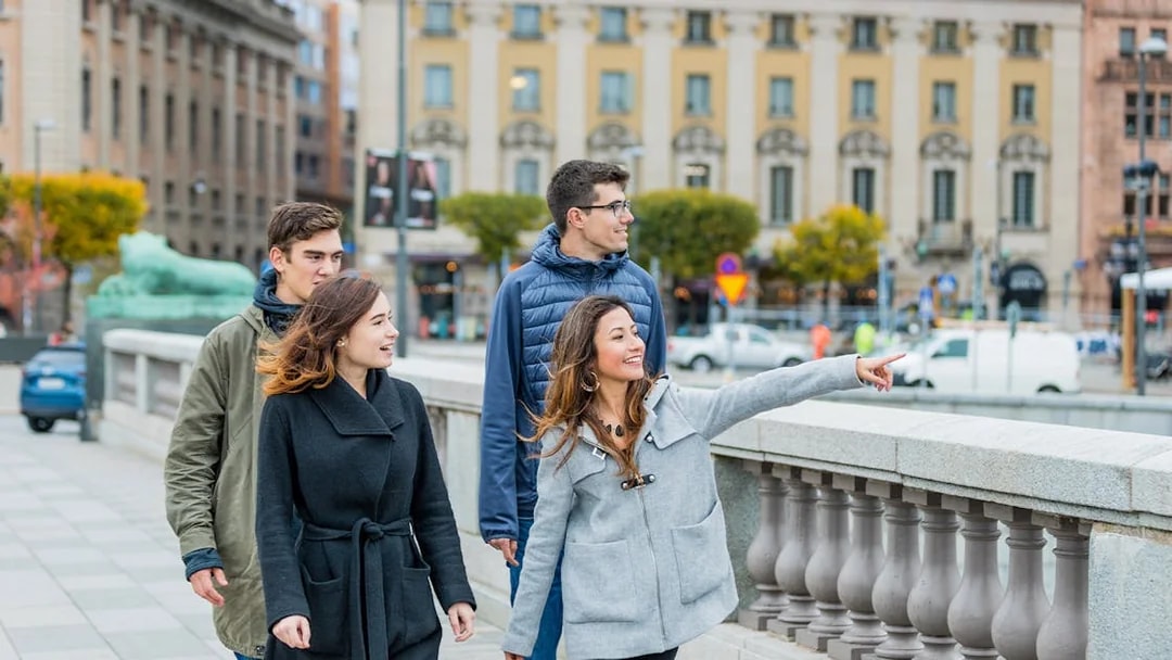 Tourists walking and pointing on a bridge in Stockholm.