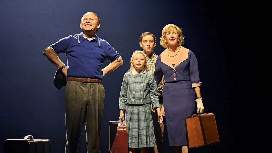 Family with suitcases on stage in "Stranger Things: The First Shadow" performance.