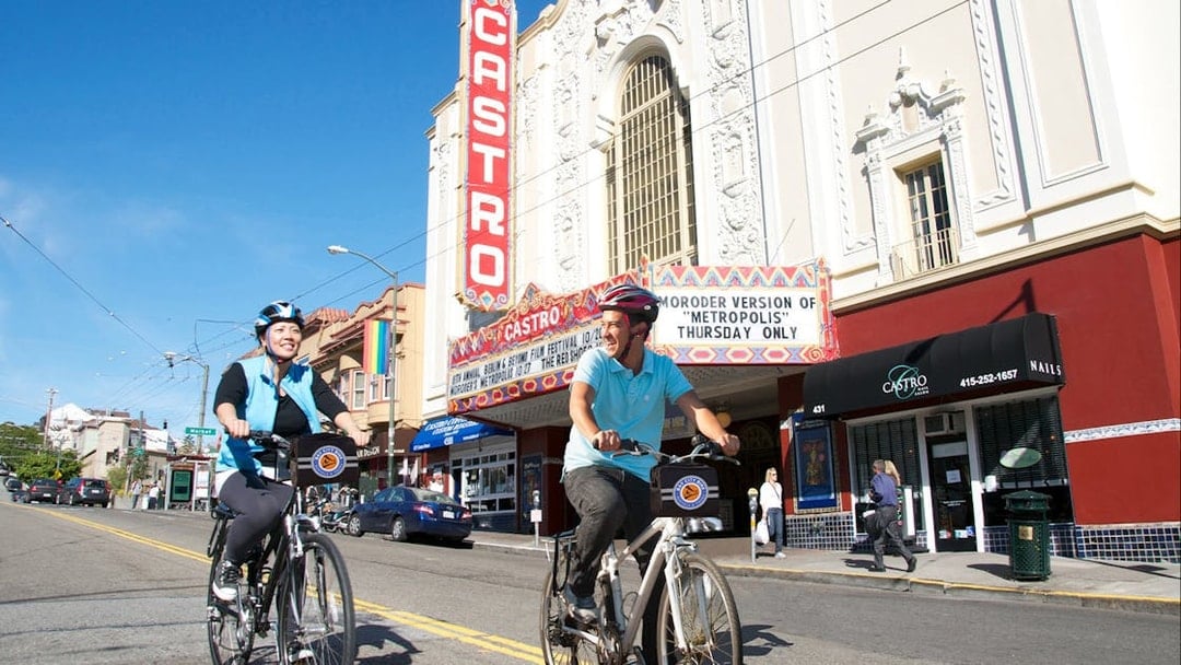 Cyclists on electric bikes in front of Castro Theatre, San Francisco.