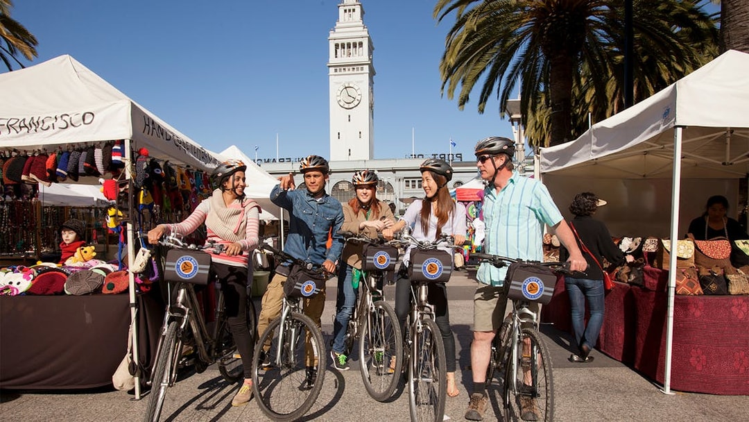 Group on electric bikes near San Francisco Ferry Building during guided tour.
