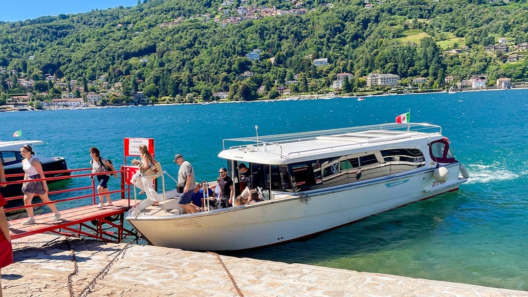 Tourists boarding a boat for the Hop-on Hop-off Isole Borromee tour on Lake Maggiore, Italy.