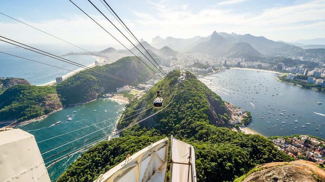 Cable car ascending Sugar Loaf Mountain with Rio de Janeiro city and ocean view.