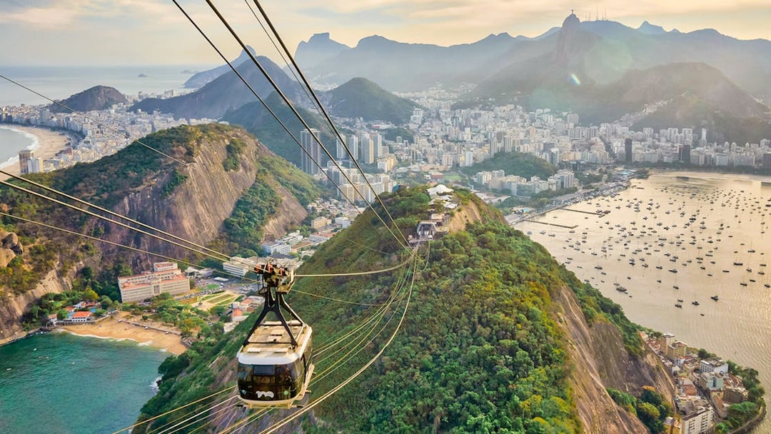 Cable car descending from Sugarloaf Mountain, Rio de Janeiro, with city and ocean views.