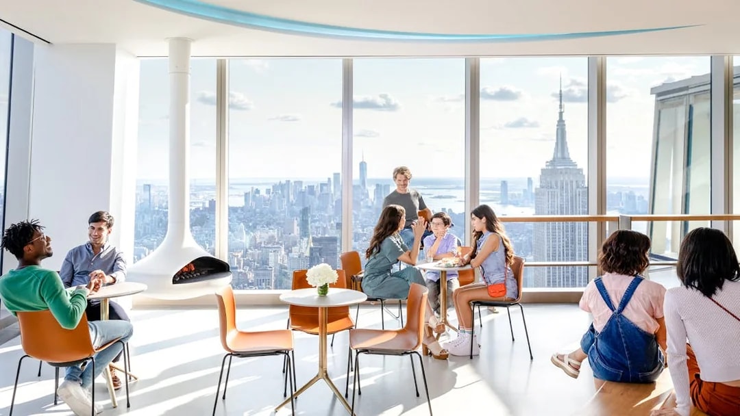 Visitors enjoying the view from SUMMIT One Vanderbilt observation deck with the Empire State Building visible.