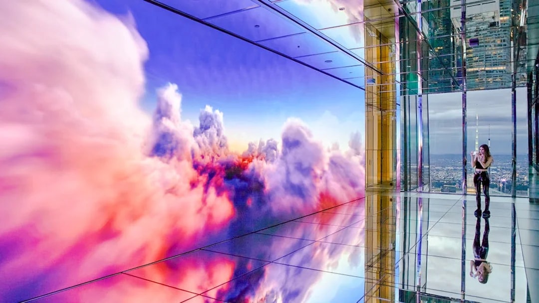 Interior of SUMMIT One Vanderbilt observation deck with mirrored floors and digital cloud display, New York City.