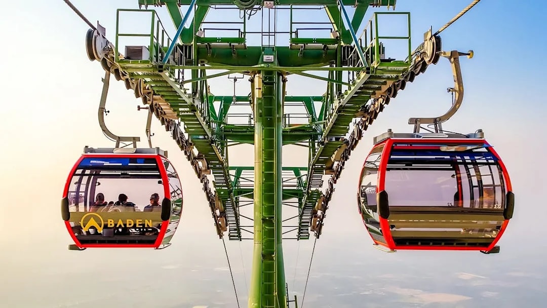 Cable car ascending Ba Den Mountains with passengers inside.