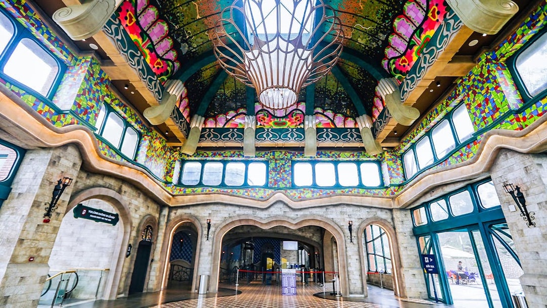 Colorful interior of Sun World Ba Den Mountain entrance hall with ornate ceiling and stained glass windows.