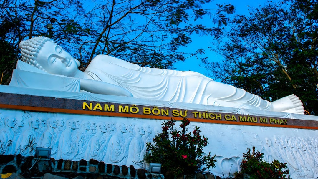 Reclining Buddha statue at Ba Den Mountain, Vietnam, surrounded by trees.