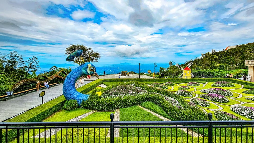 Garden with peacock sculpture and windmill at Sun World Ba Na Hills.