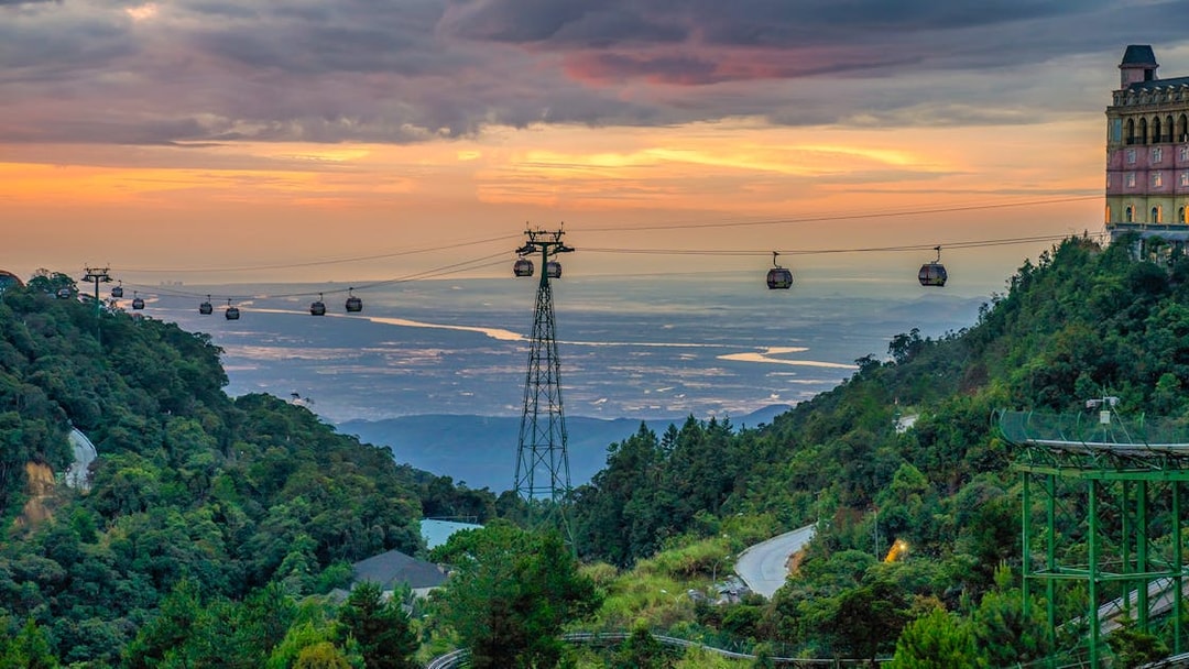 Cable cars over lush hills at sunset in Ba Na Hills, Vietnam.
