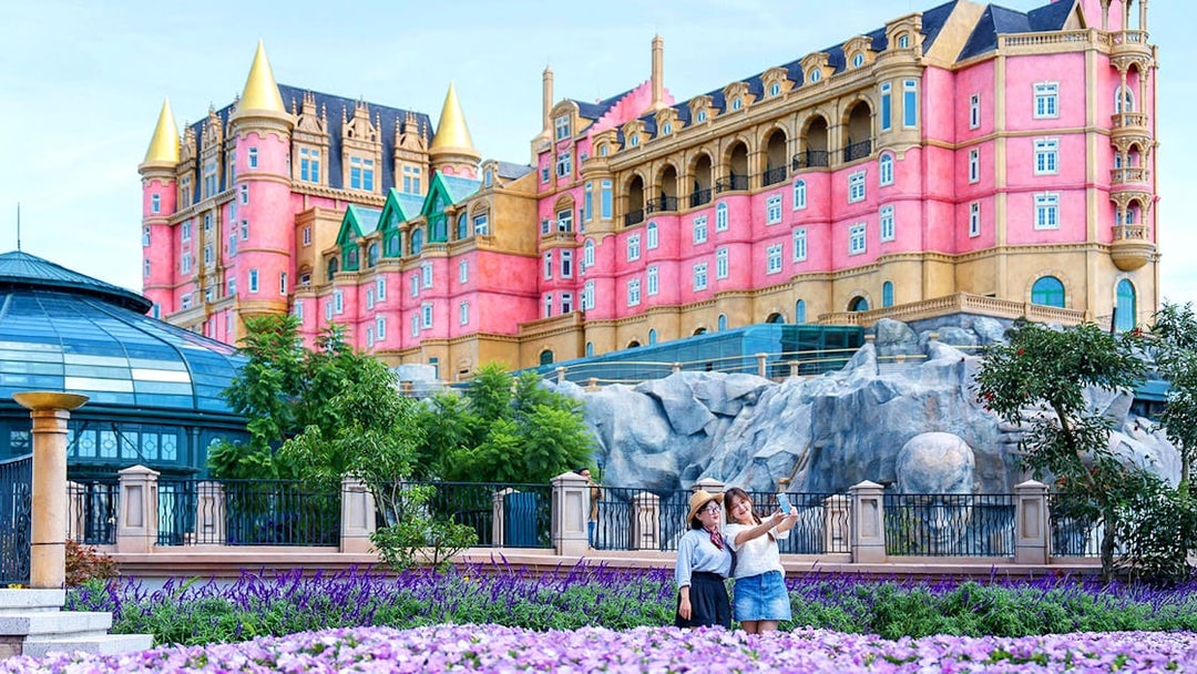 Tourist taking a photo in front of Luna Castle, Ba Na Hills, Vietnam.