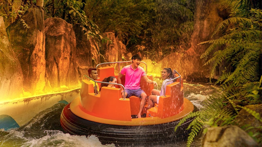 Guests enjoying a raft ride through Grand Canyon river rapids surrounded by lush greenery.