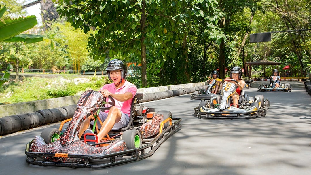 Go karting track at Sunway Lagoon theme park with racers in helmets.