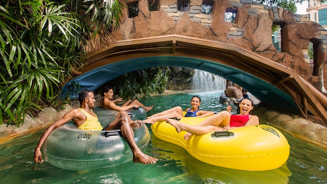 Visitors enjoying a lazy river ride at Sunway Lagoon's water park, Zambezi River attraction.