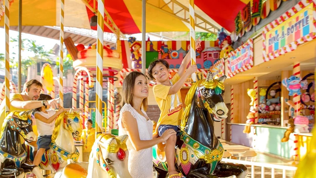 Family enjoying carousel ride at Sunway Lagoon theme park.