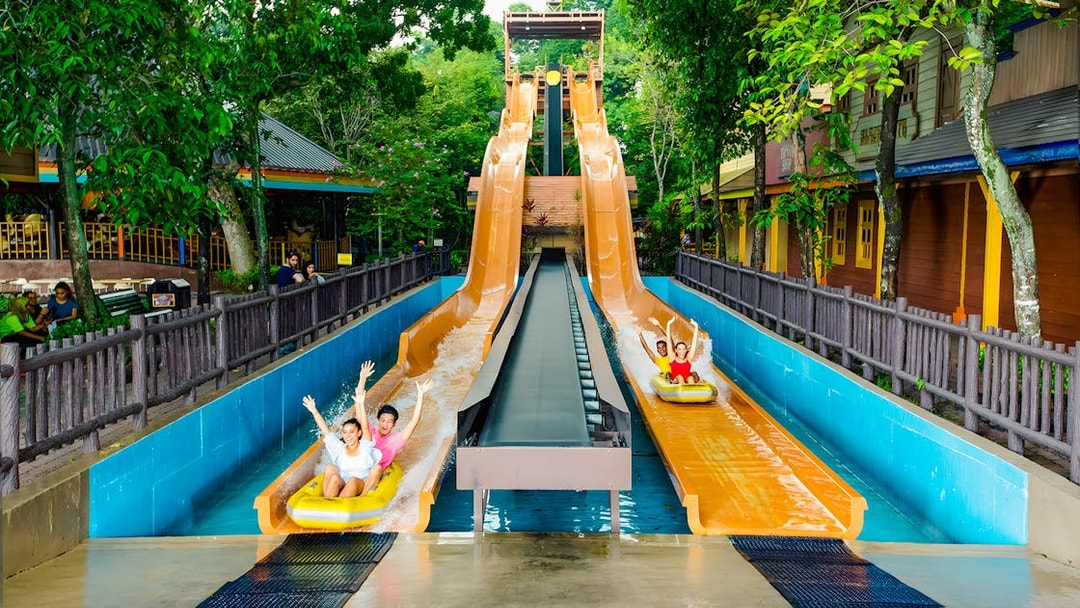 Visitors enjoying water slides at Sunway Lagoon amusement park.