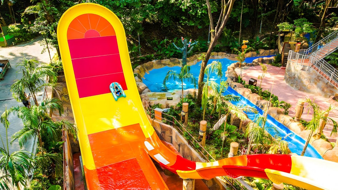Water slide at Sunway Lagoon amusement park surrounded by tropical greenery.