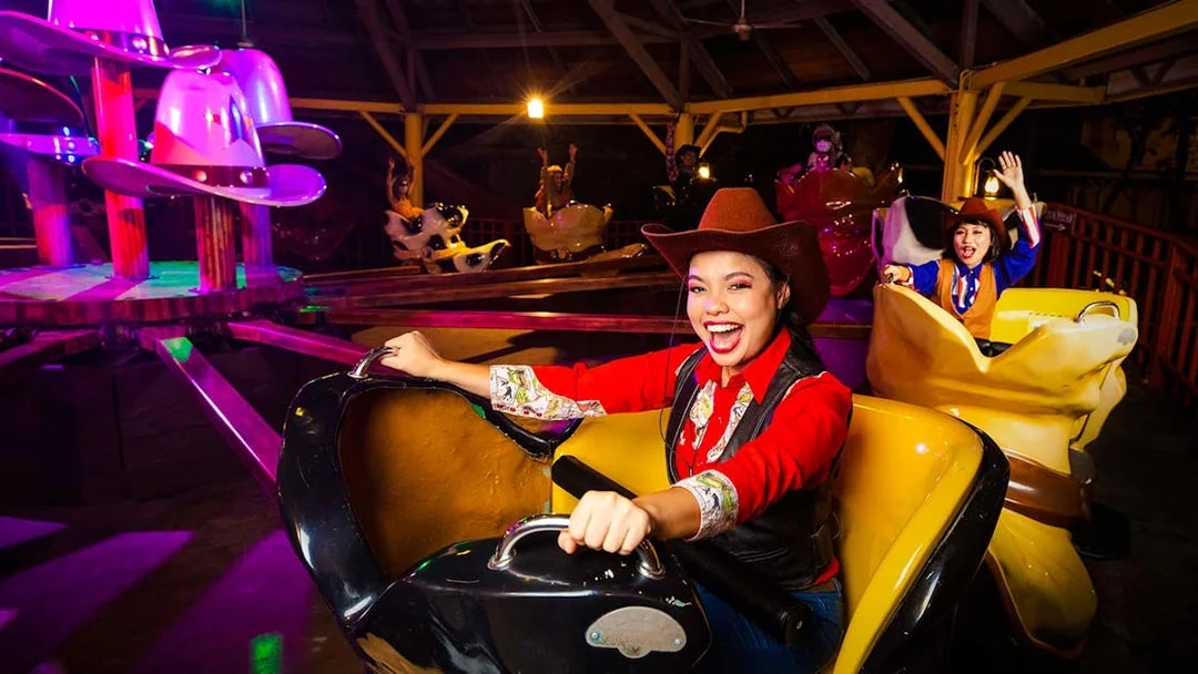 Visitors enjoying a cowboy-themed ride at Sunway Lagoon night park.