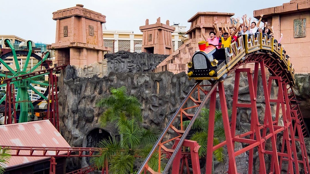 Roller coaster ride at Sunway Lagoon with excited visitors, Malaysia.