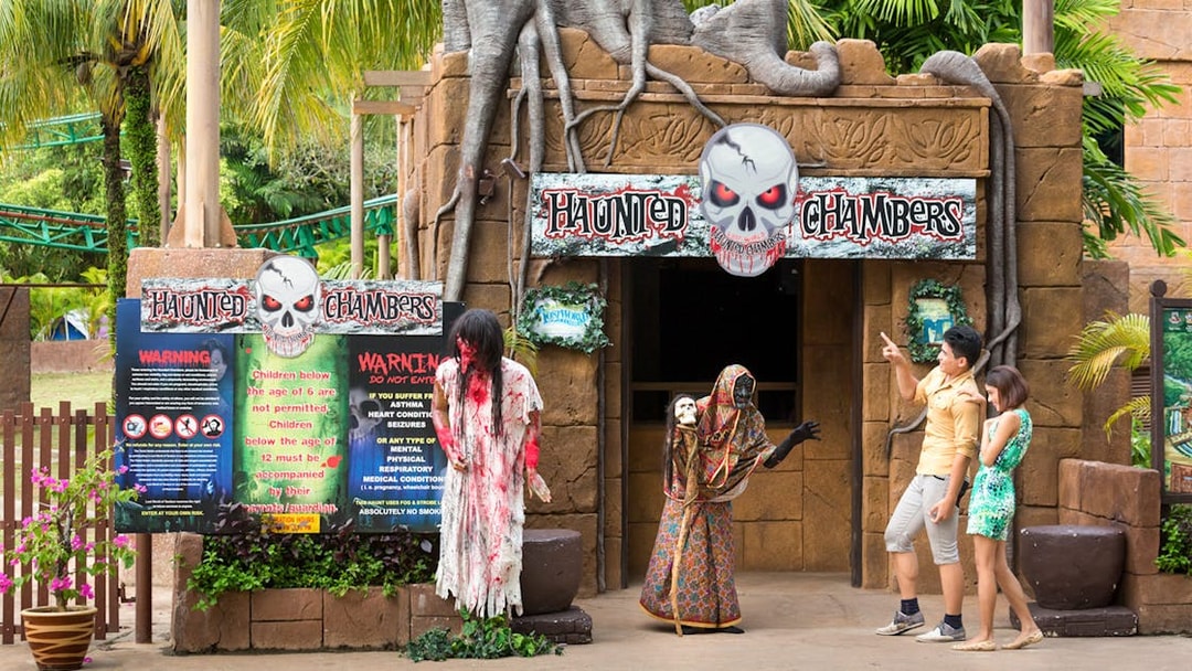 Haunted Chambers entrance at Sunway Lost World of Tambun with visitors and costumed figures.