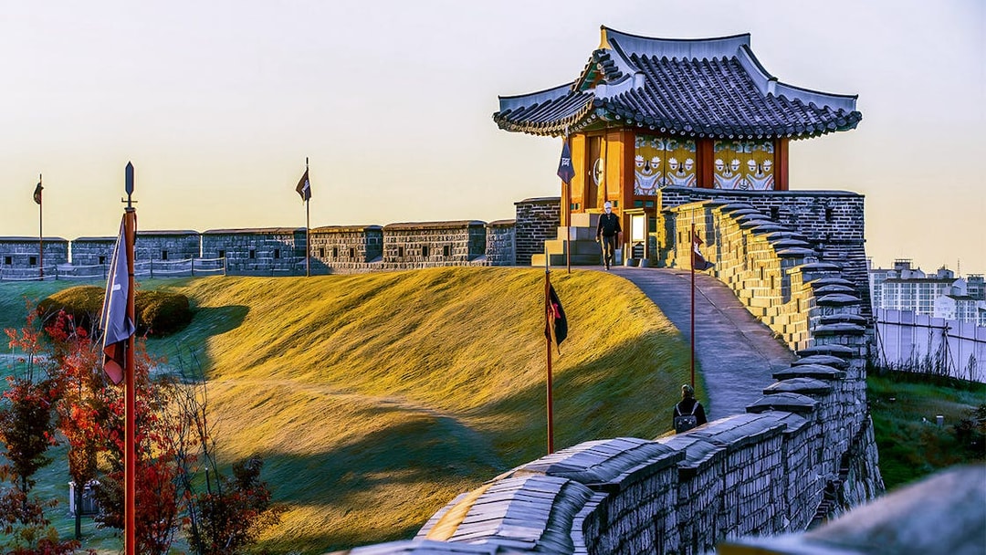 Suwon Hwaseong Fortress wall and traditional pavilion during Korean Folk Village tour.