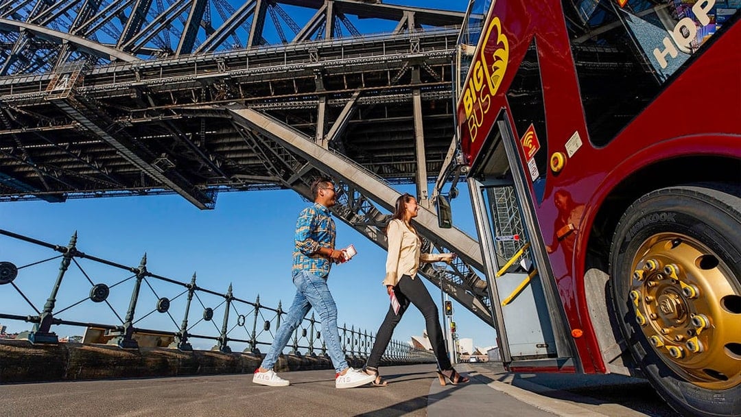 Visitors boarding Big Bus Sydney at Dawes Point with Sydney Harbour Bridge in the background.