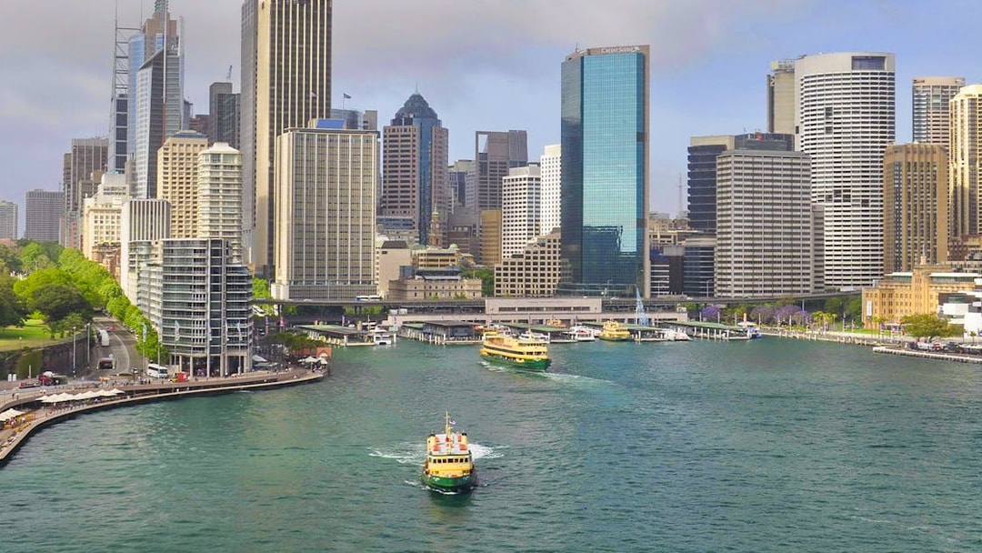 Ferry cruising through Sydney Harbour with city skyline in the background.