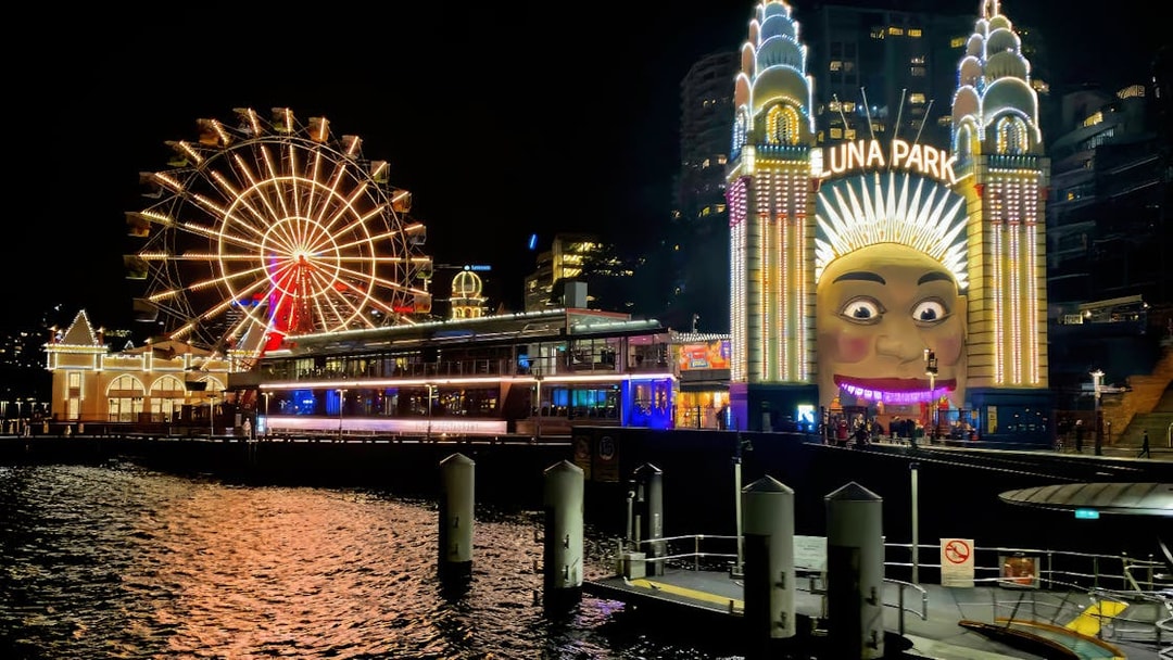 Luna Park entrance and Ferris wheel illuminated at night, Sydney Night Tour.