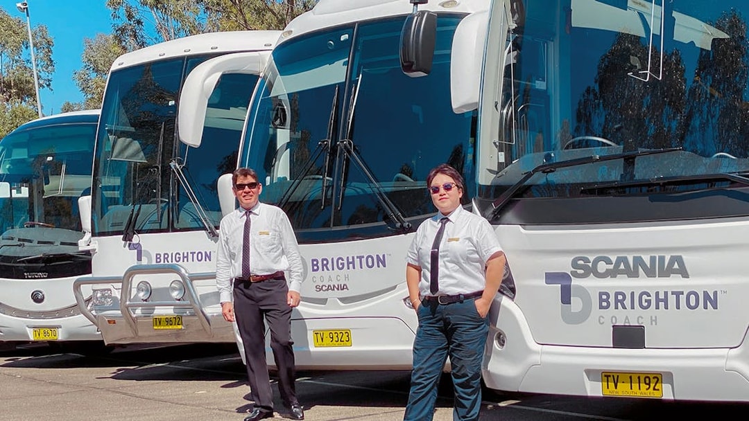 Tour guides standing in front of Brighton Coach buses for Sydney Night Tour.