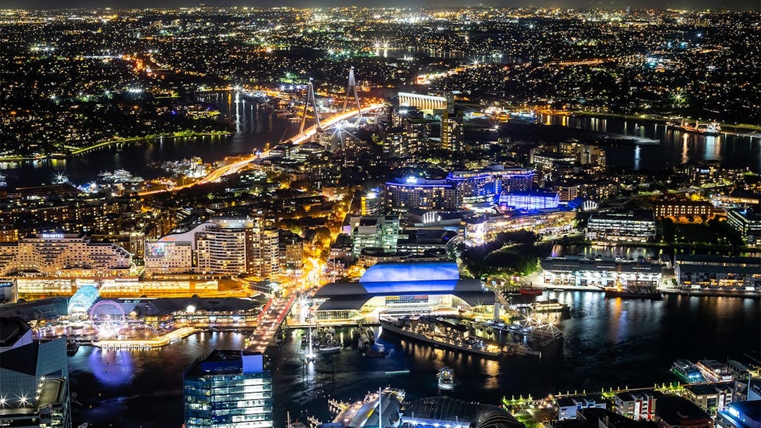 Night view of Sydney from Sydney Eye Tower, featuring illuminated cityscape and harbor.