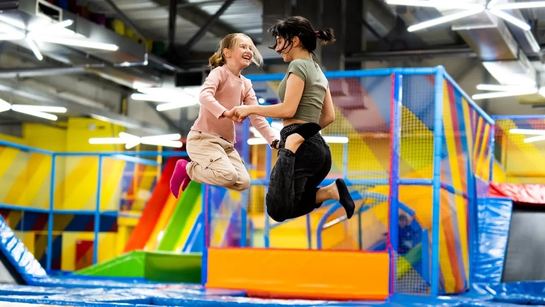 Children jumping on trampolines at T-Play Khatib indoor playground.
