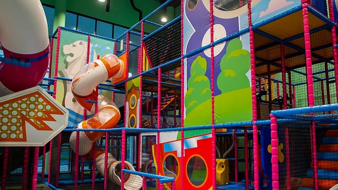 Indoor playground with colorful slides and climbing structures at T-Play Khatib.