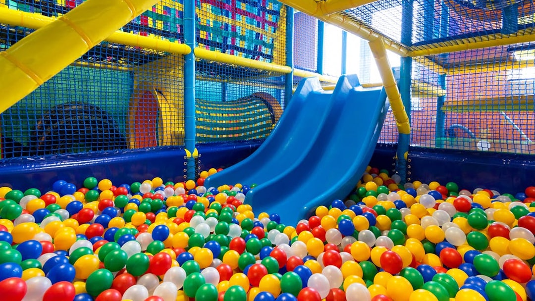 Indoor playground with blue slides and colorful ball pit at T-Play Khatib.
