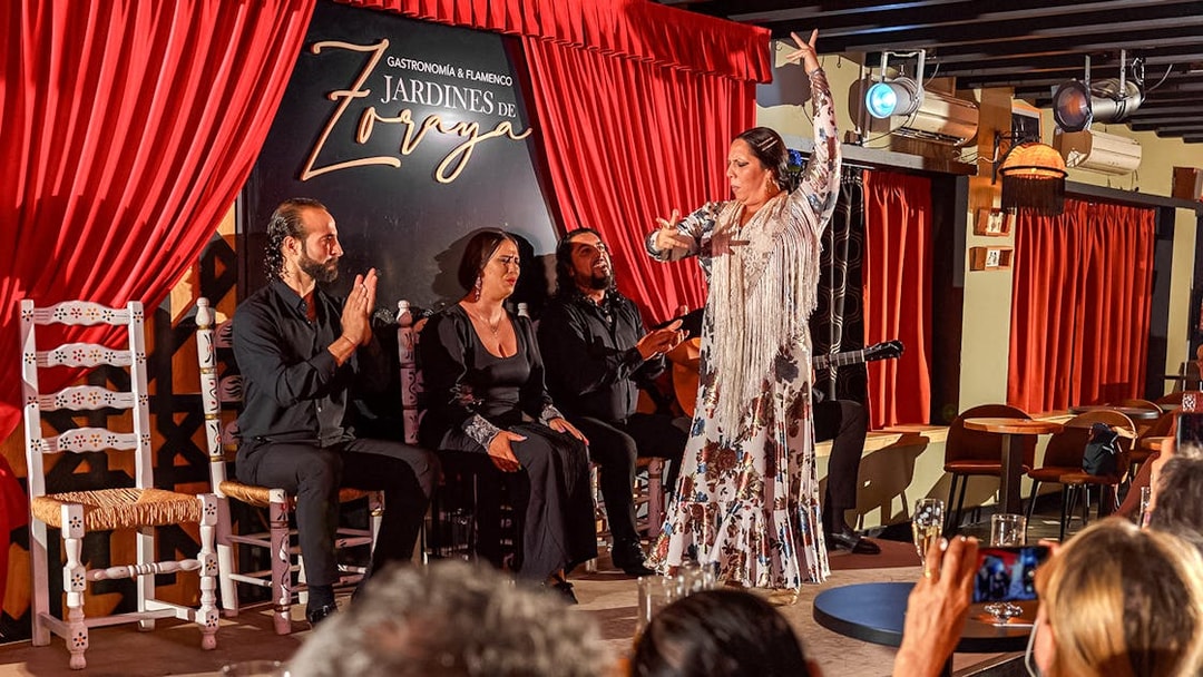 Flamenco dancer performing at Tablao Jardines de Zoraya with musicians in Granada.